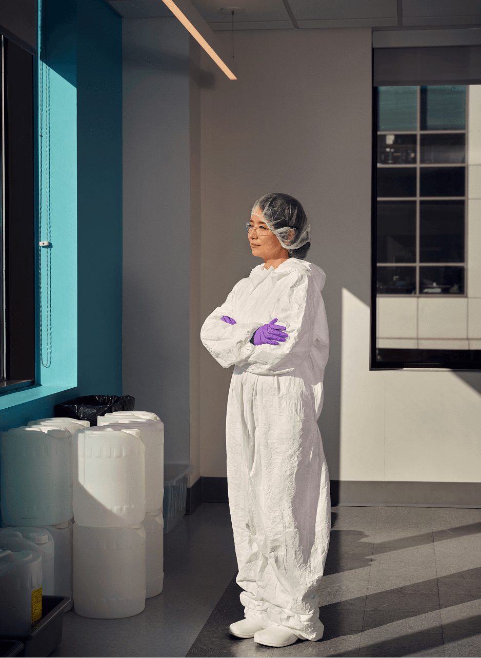 Scientist wearing PPE looking out the window in a lab